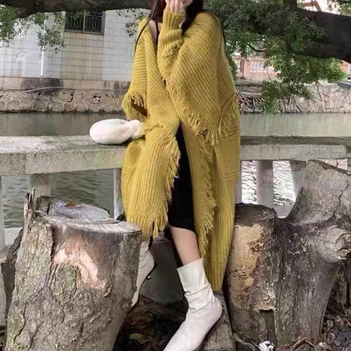 a woman sitting on a bench under a tree