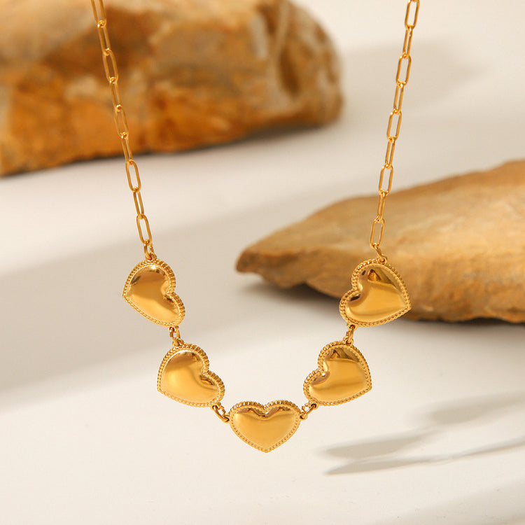 a gold necklace with hearts on it