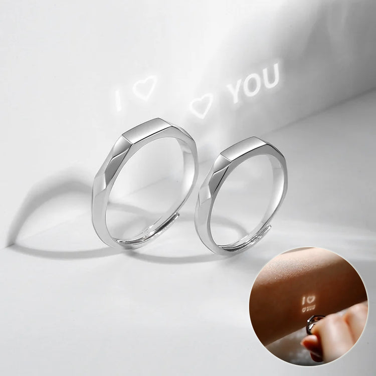 a couple of silver rings with a picture of a person's finger