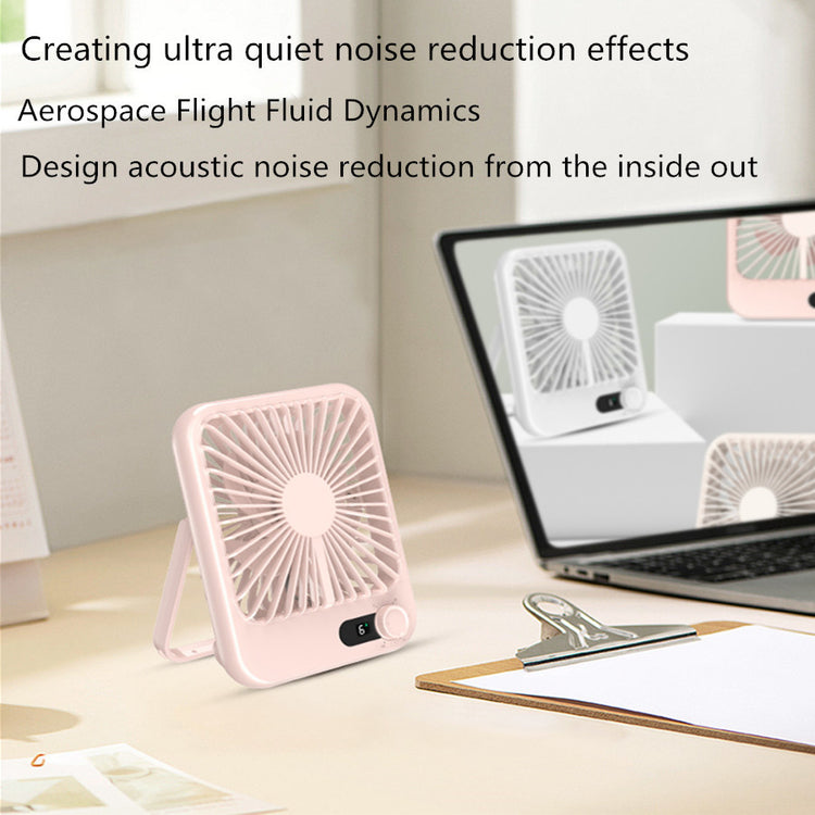 a desk with a laptop and a fan