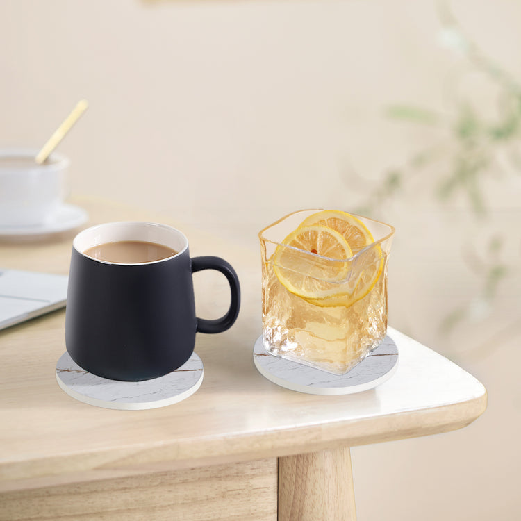 a cup of coffee and a glass of ice cube on a table