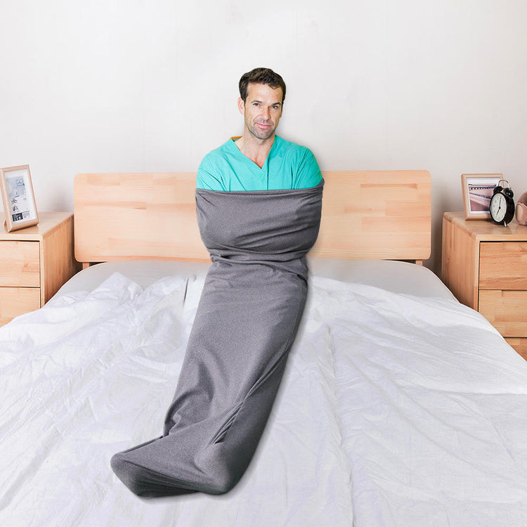 a man wrapped in a blanket on a bed