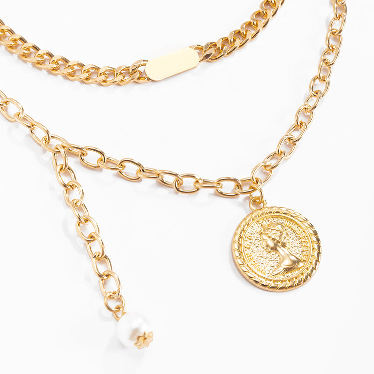 a gold chain necklace with a coin and a pearl