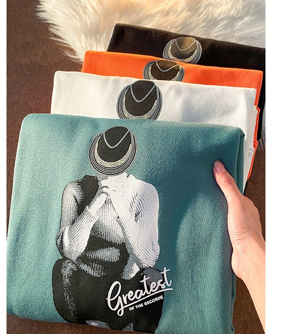 a hand holding a stack of t-shirts