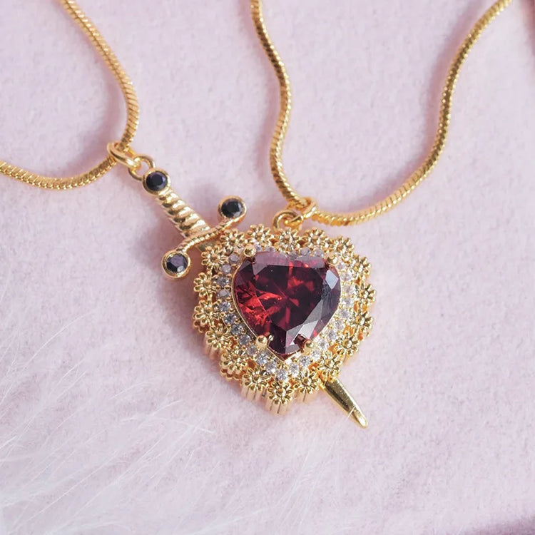 a gold necklace with a heart and a sword