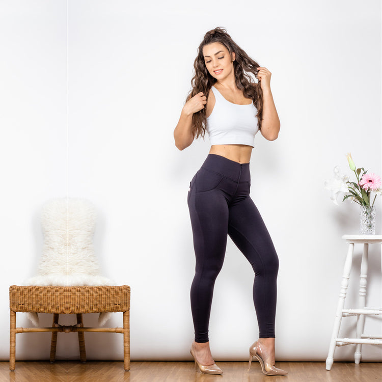 a woman in tight pants and a white tank top