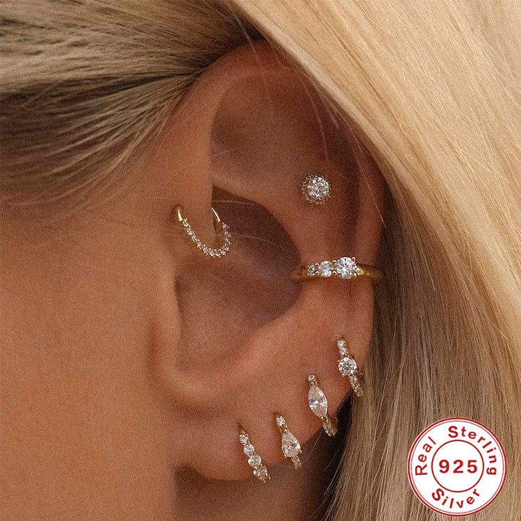 a close up of a woman's ear with multiple earrings