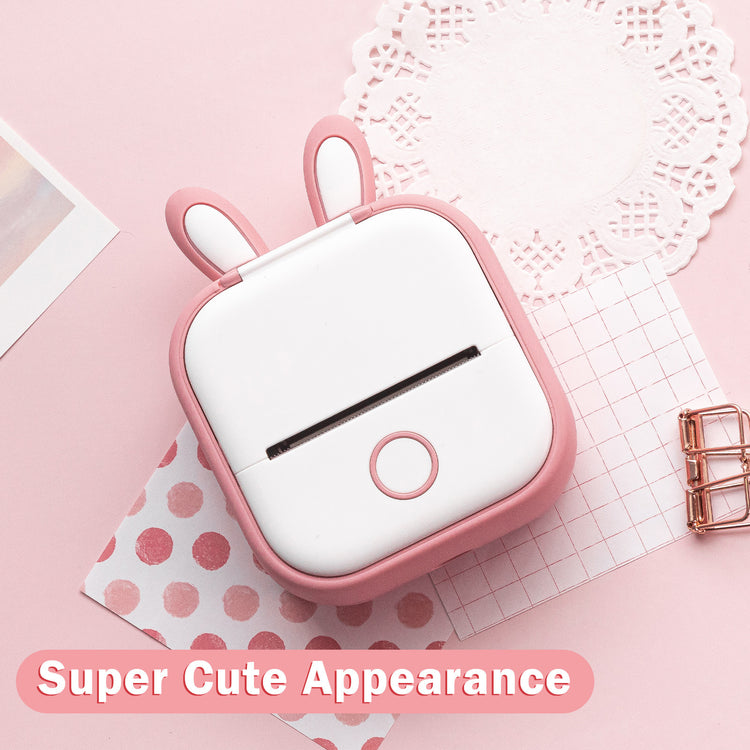 a white and pink object with a bunny face on top of a pink surface