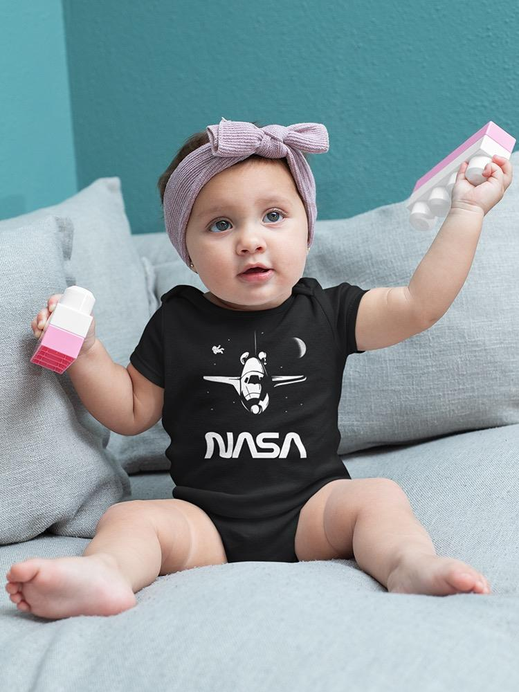 a baby with a purple headband holding a pink and white toy