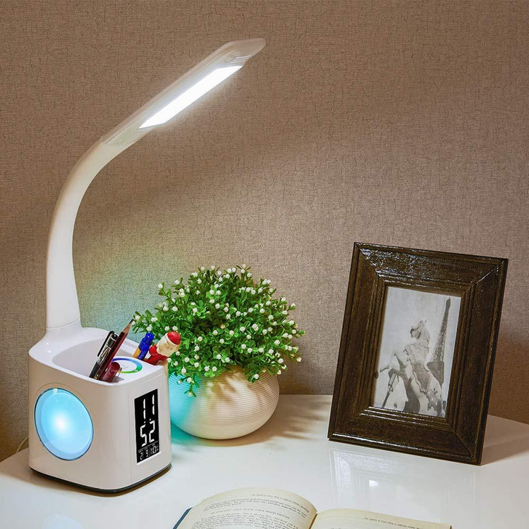a desk with a book and a lamp