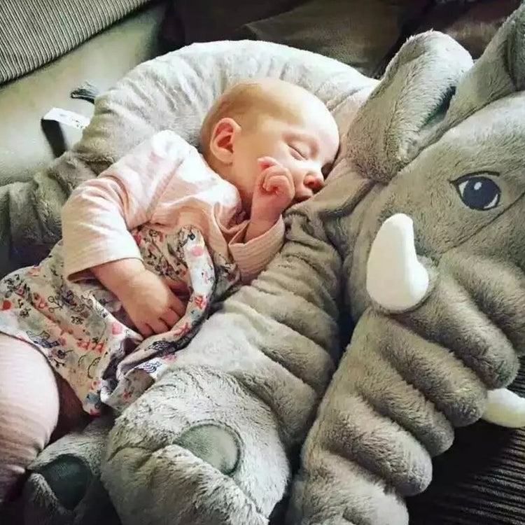 a baby sleeping on a stuffed elephant