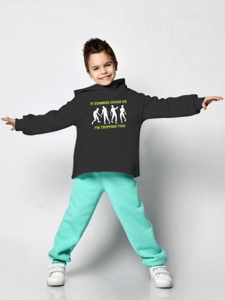 a boy wearing a black sweatshirt with white text and green pants