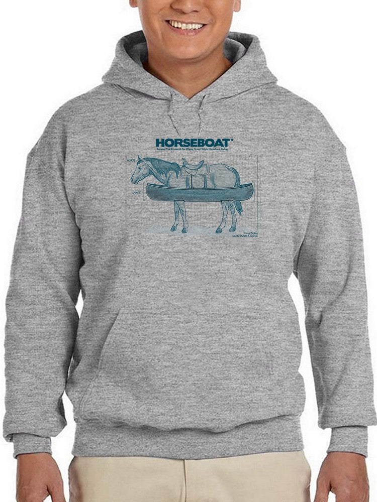 a person wearing a grey sweatshirt with a horse and a boat