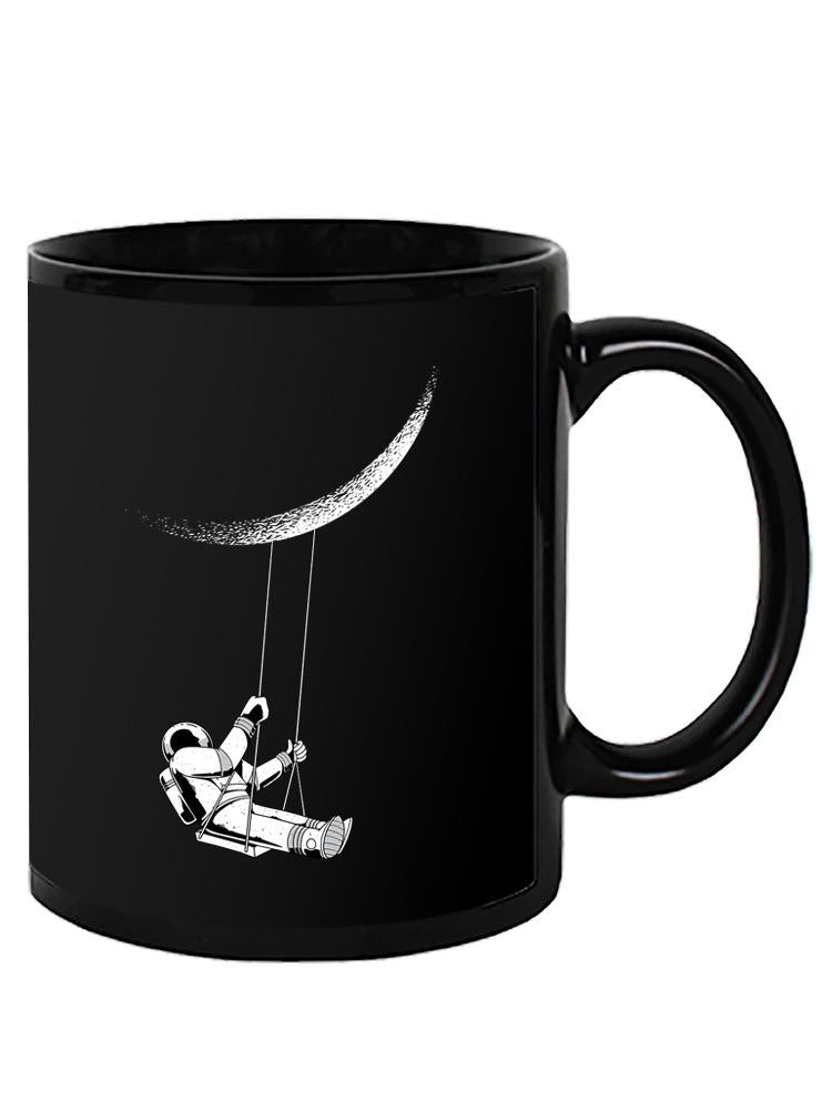a black mug with a drawing of a astronaut swinging on a string