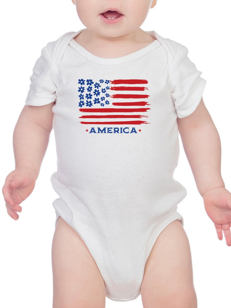 a baby wearing a white bodysuit with a flag on it