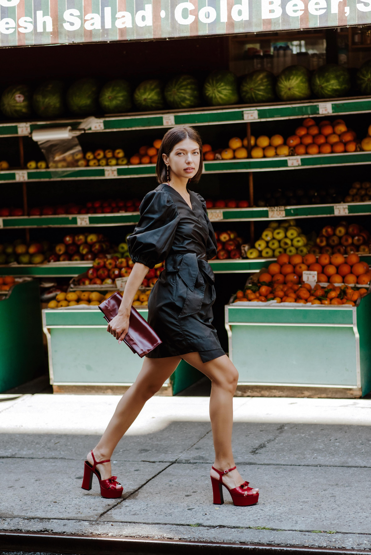 a woman walking in front of fruit shelves