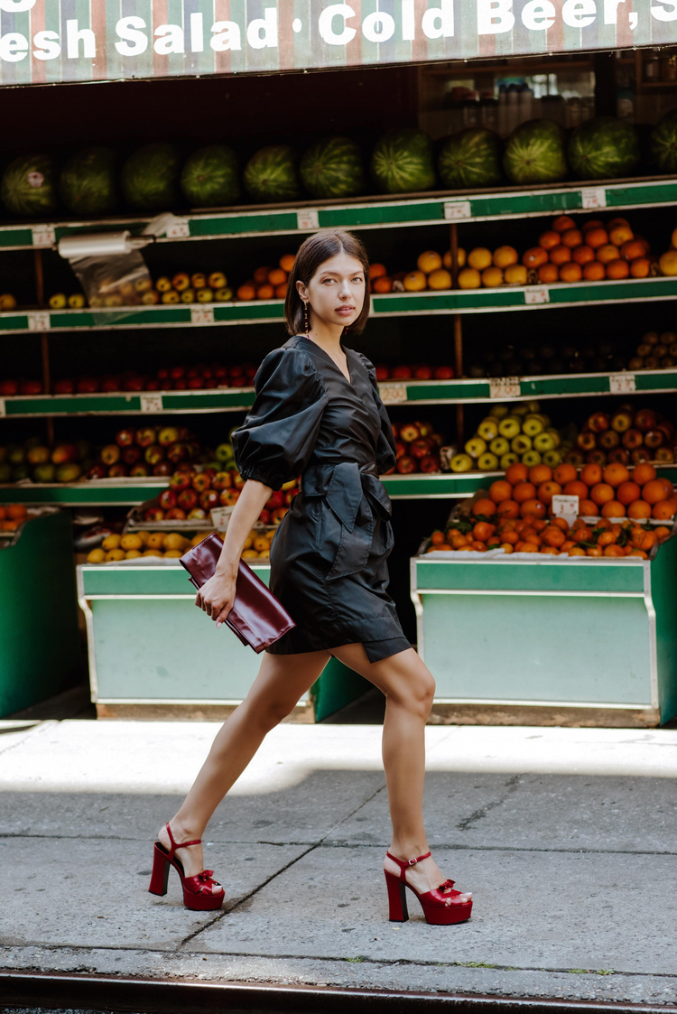 a woman walking in front of fruit shelves