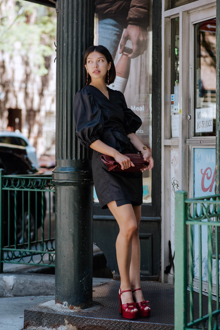 a woman leaning against a pole