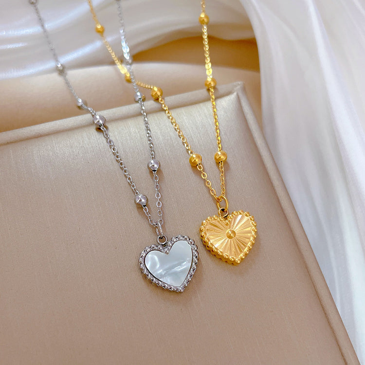 a heart shaped necklaces on a gold and silver chain