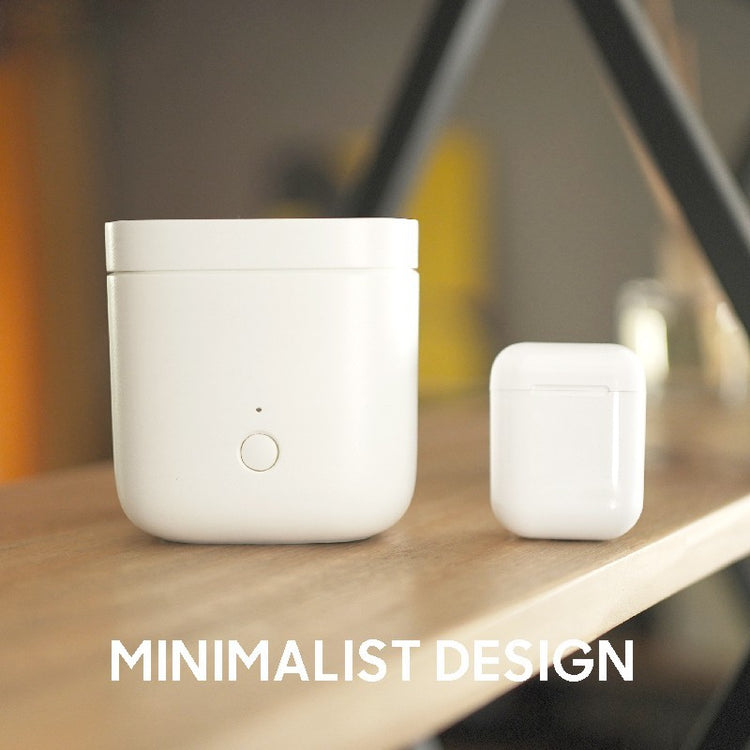 a white square box with a button on a wooden surface