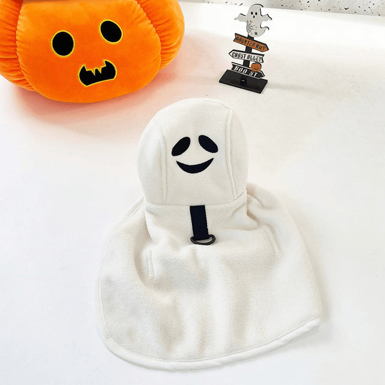 a white towel with a face on it next to a stuffed pumpkin