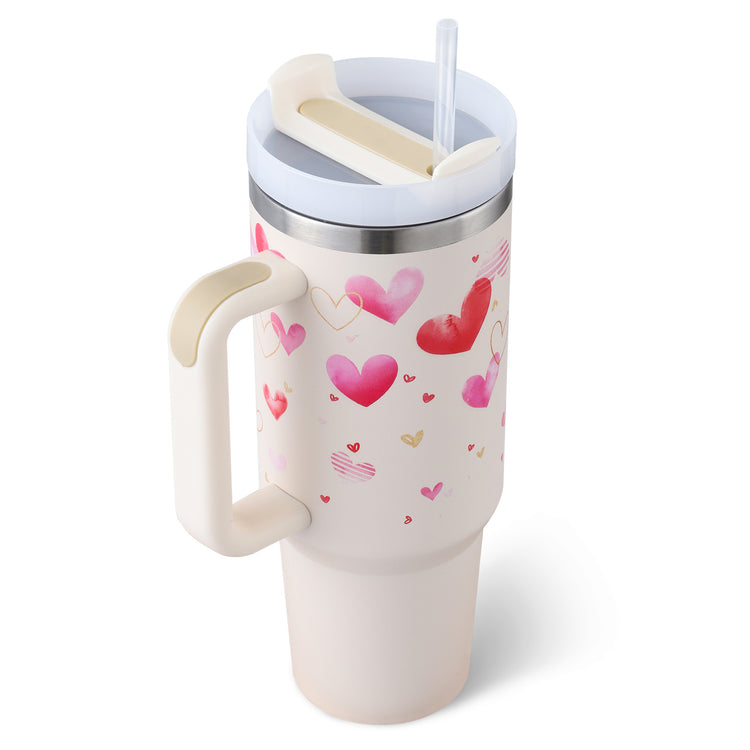 a white and pink coffee mug with hearts and straw