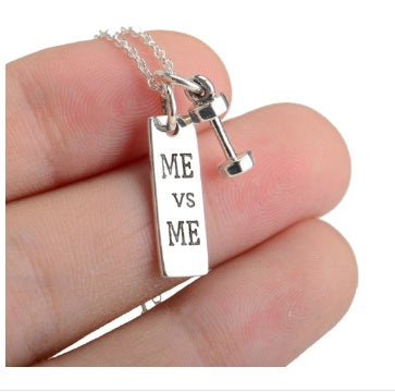 a hand holding a silver barbell necklace