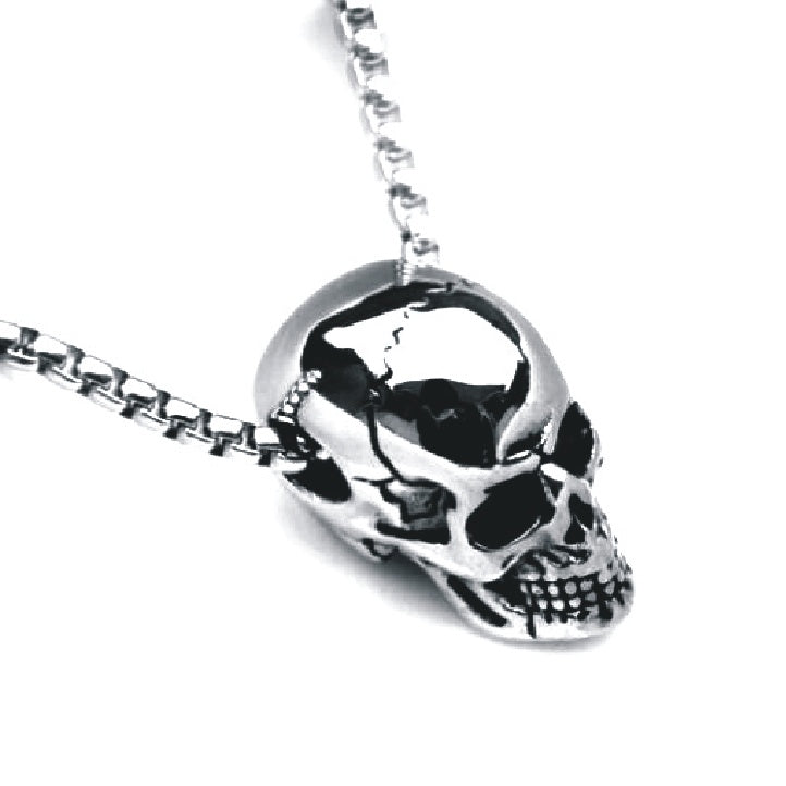 a silver skull necklace on a chain