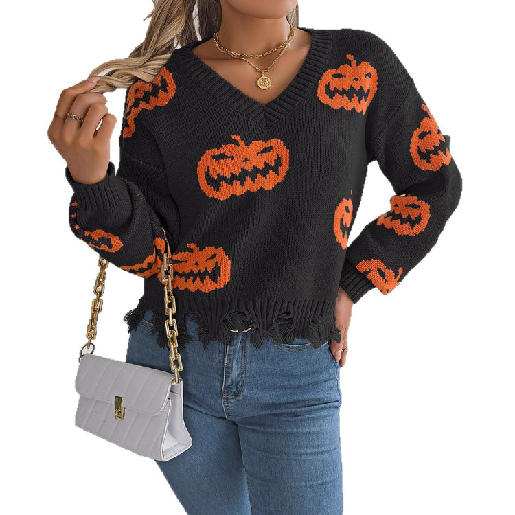 a woman wearing a black and orange sweater with pumpkins on it
