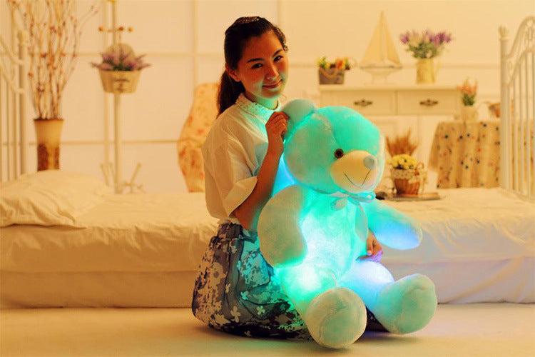 a woman holding a blue teddy bear