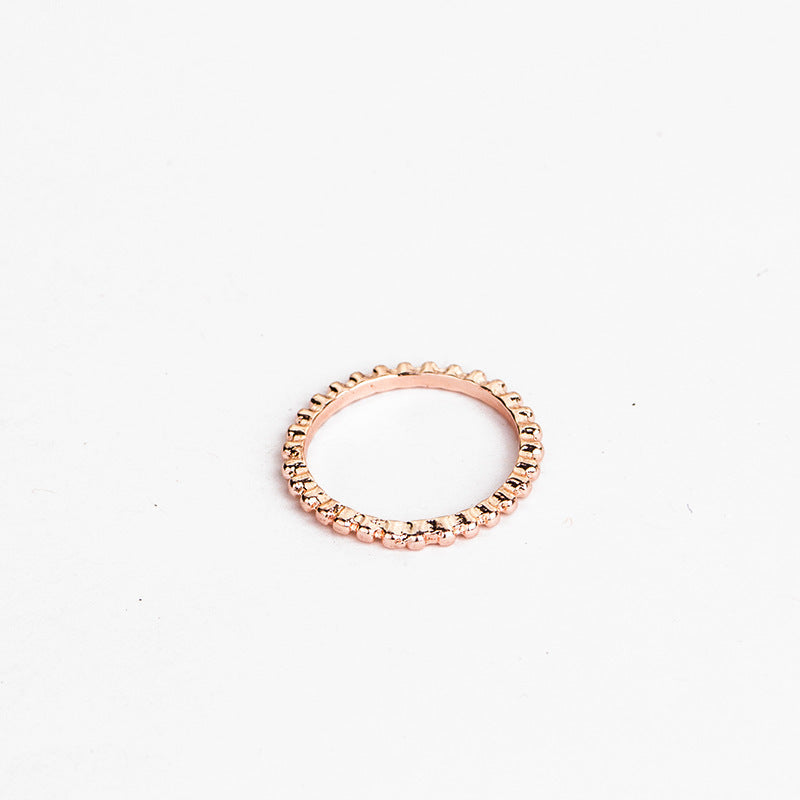 a gold ring on a white surface