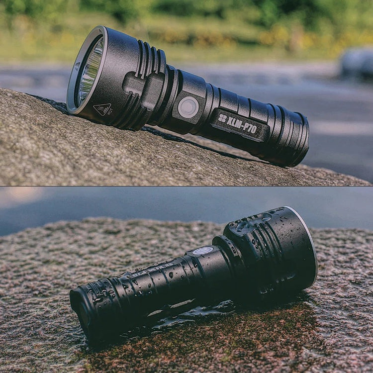 a black flashlight on a rock