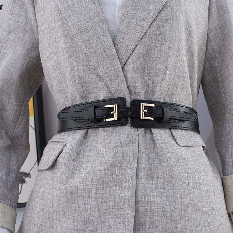 a woman wearing a suit with a belt