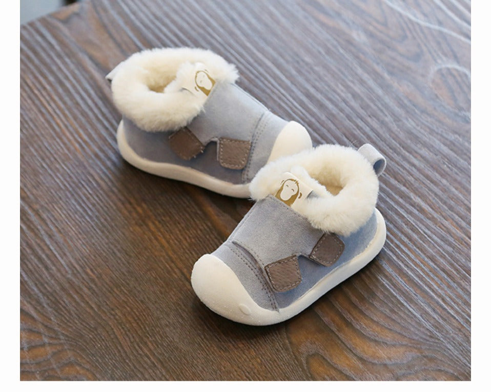 a pair of baby shoes on a wood surface