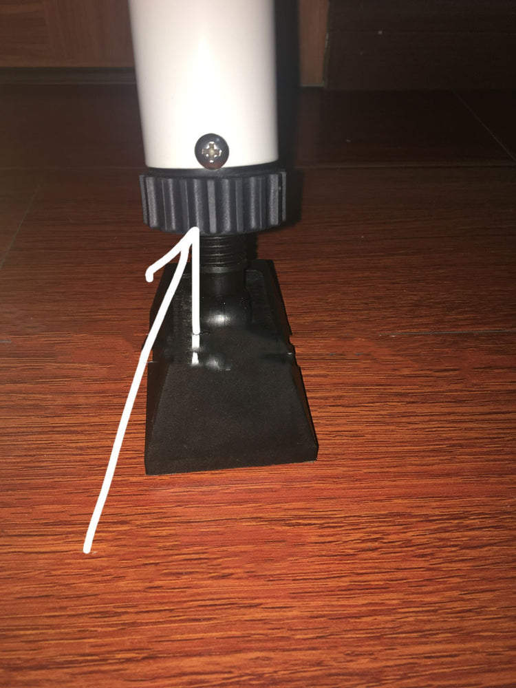 a white tube with a black cap on a black base