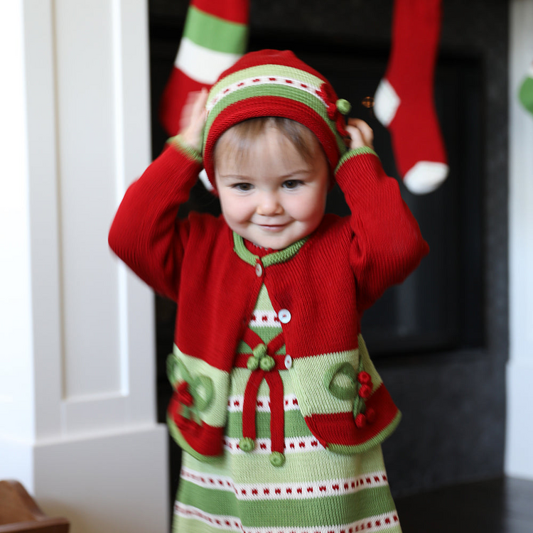 a child wearing a red and green outfit