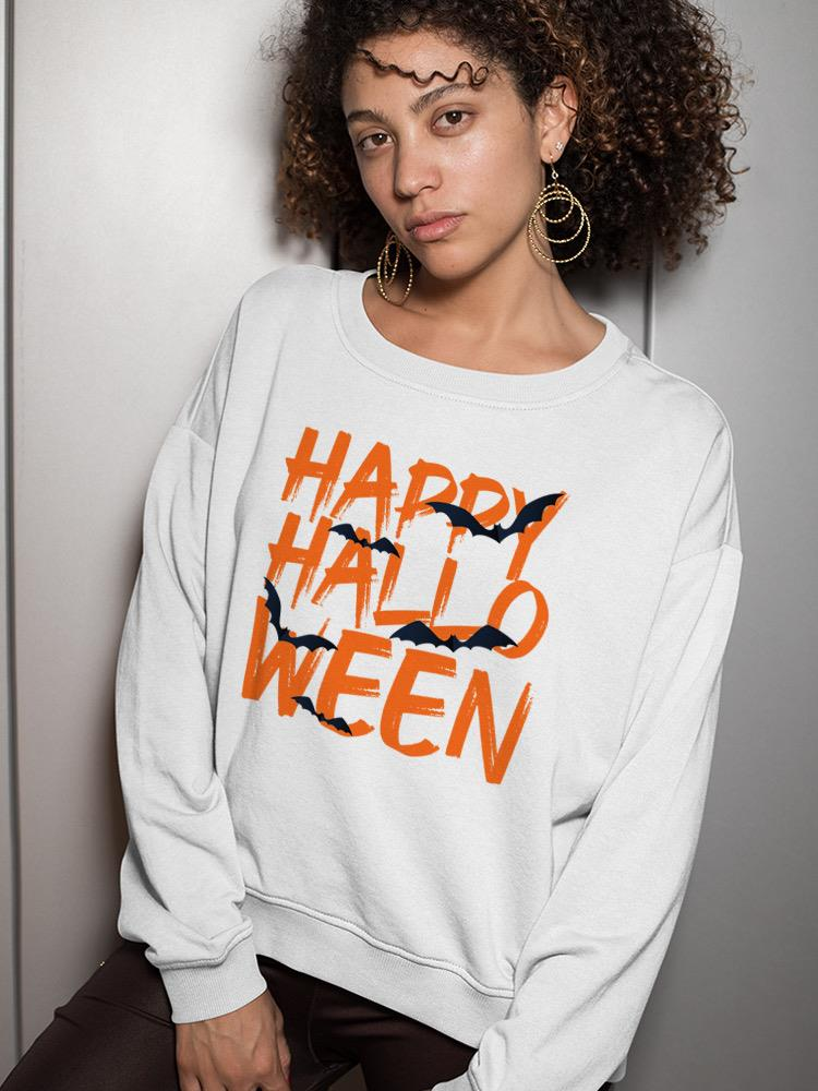 a woman with curly hair wearing a white sweatshirt with orange text