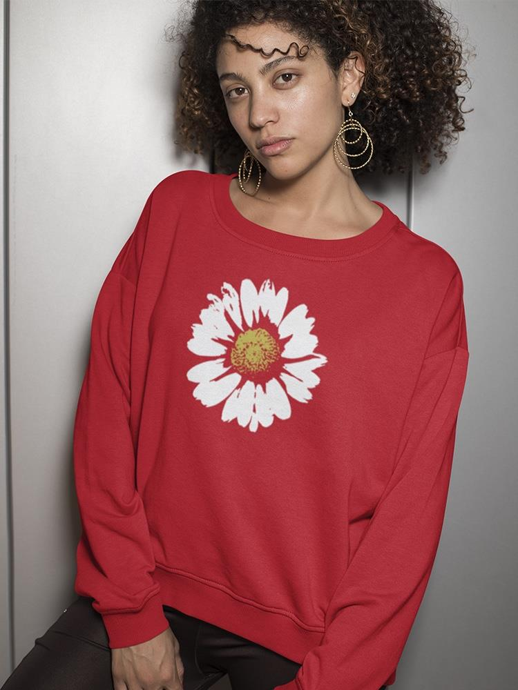 a woman with curly hair wearing a red sweater with a flower on it