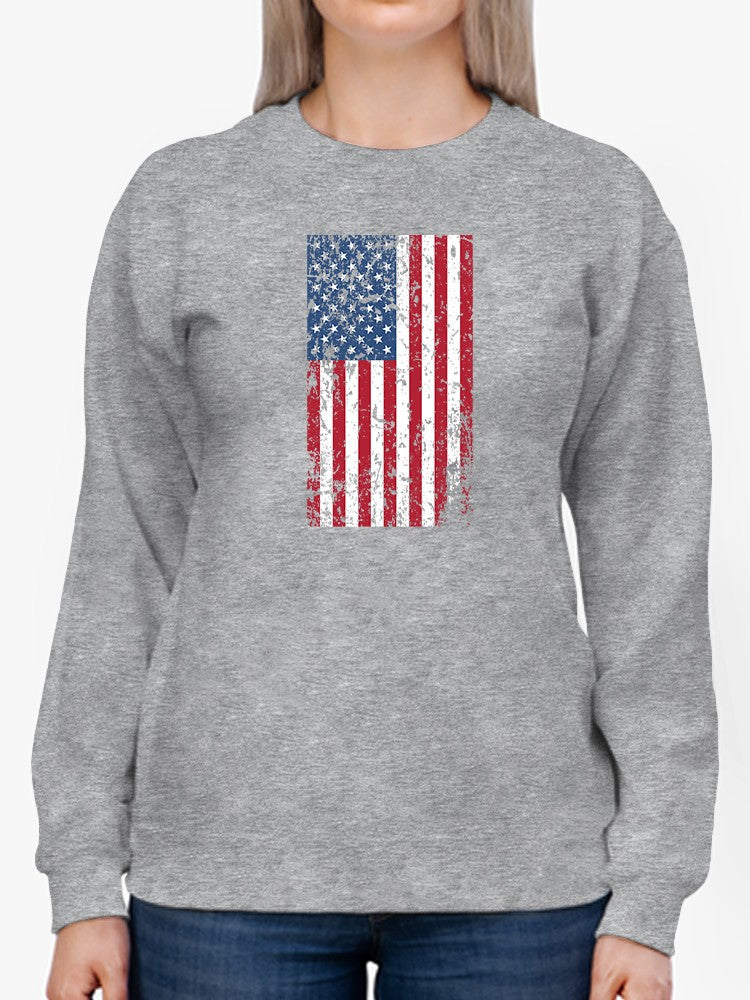 a person wearing a grey sweatshirt with a flag on it