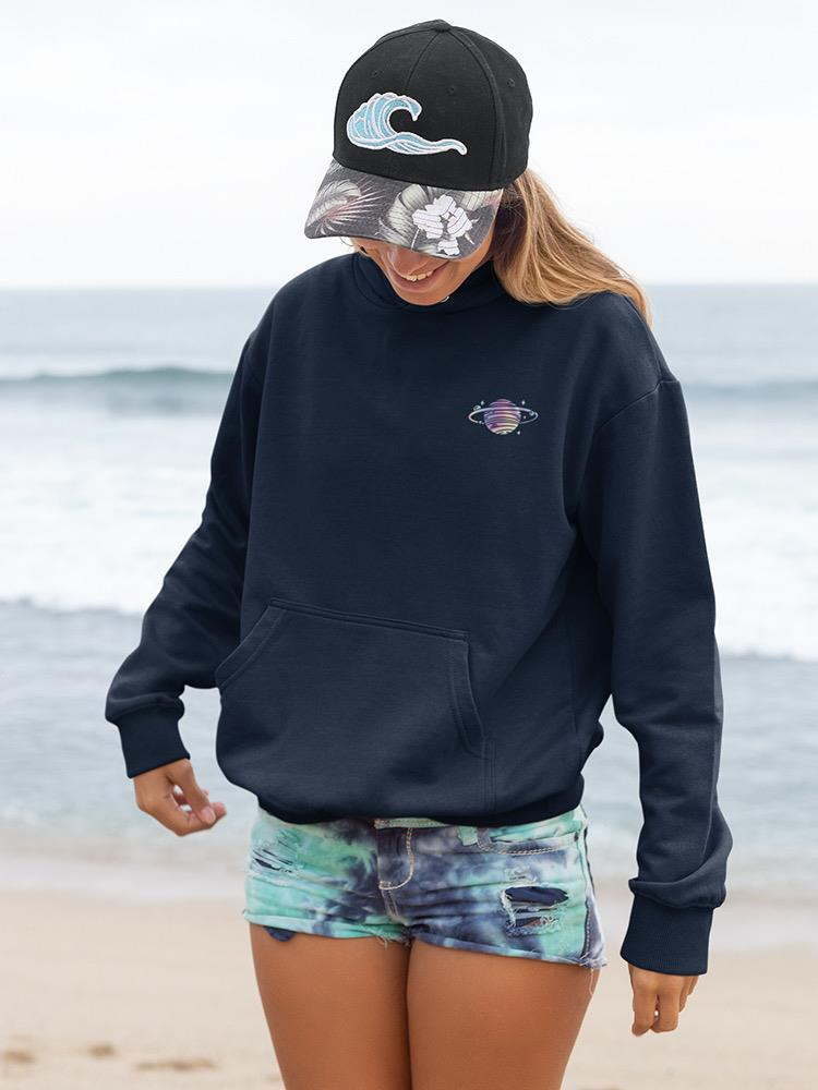 a woman wearing a hat and sweatshirt on a beach