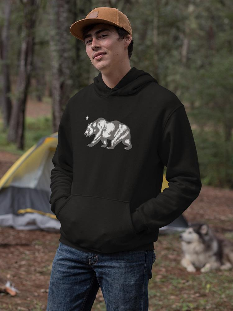 a man wearing a hat and a sweatshirt with a bear on it