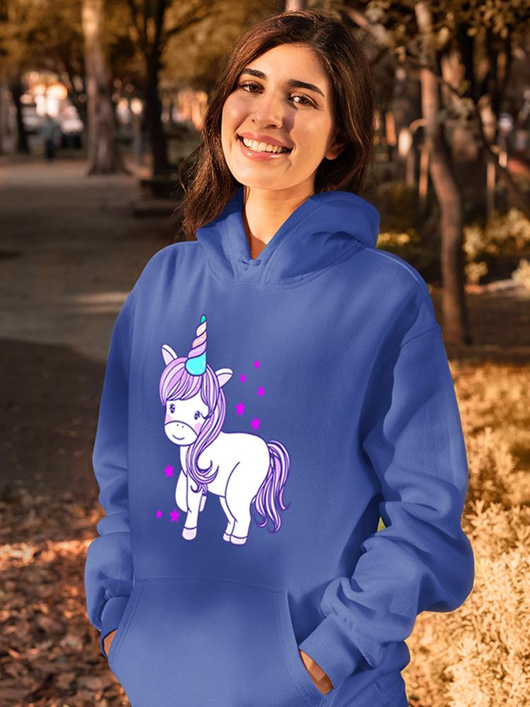 a woman smiling with a unicorn on her hoodie