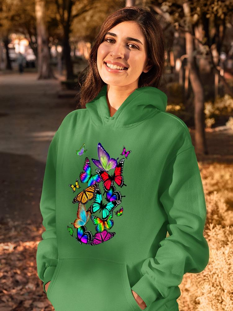 a woman smiling in a green sweatshirt with butterflies on it