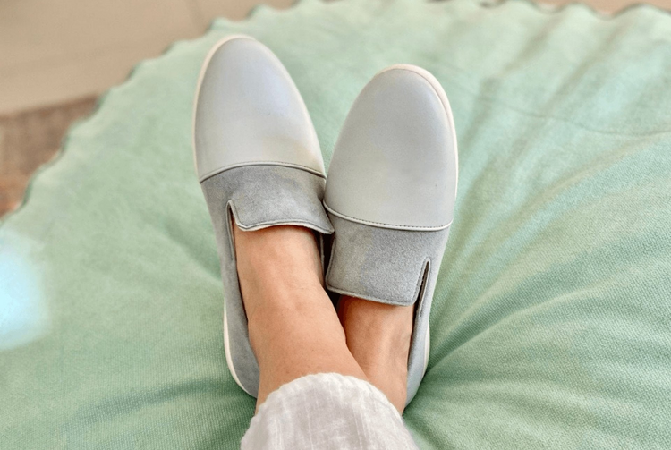a person's feet wearing white shoes