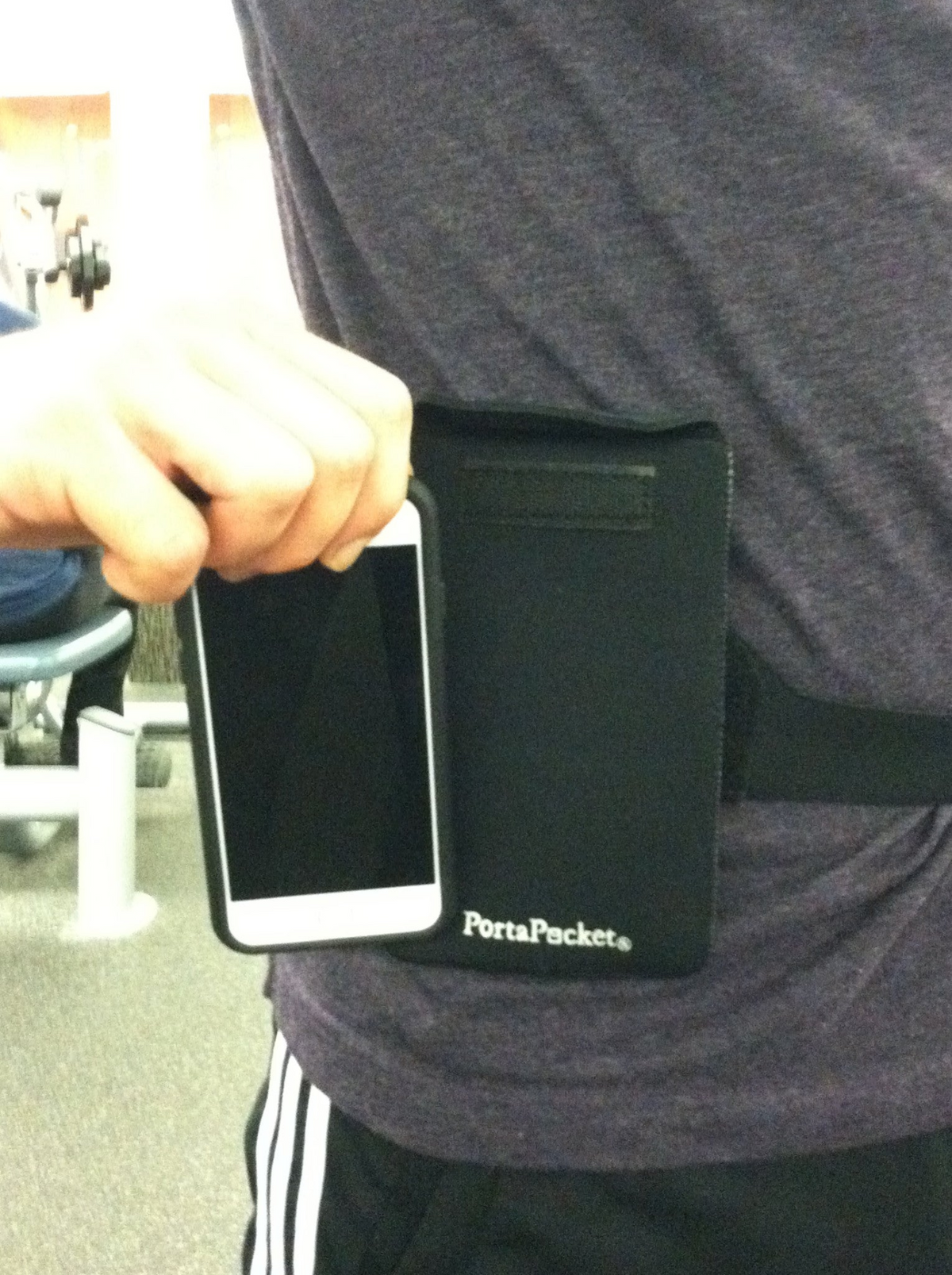 a person holding a phone in a waist bag