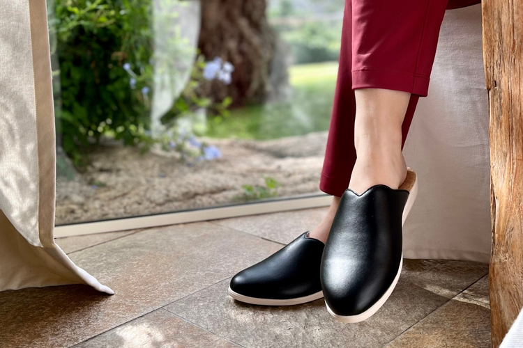 a person wearing black slippers