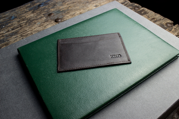 a leather card holder on a green folder