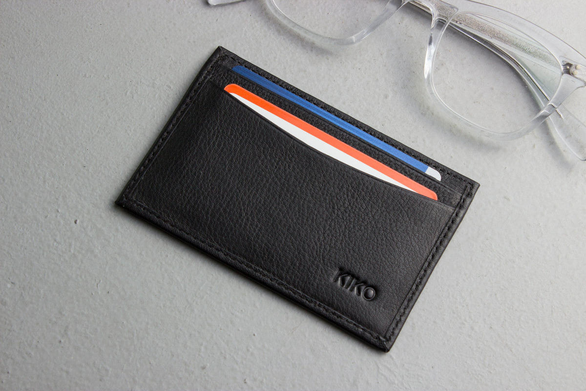 a black leather card holder with credit cards in it