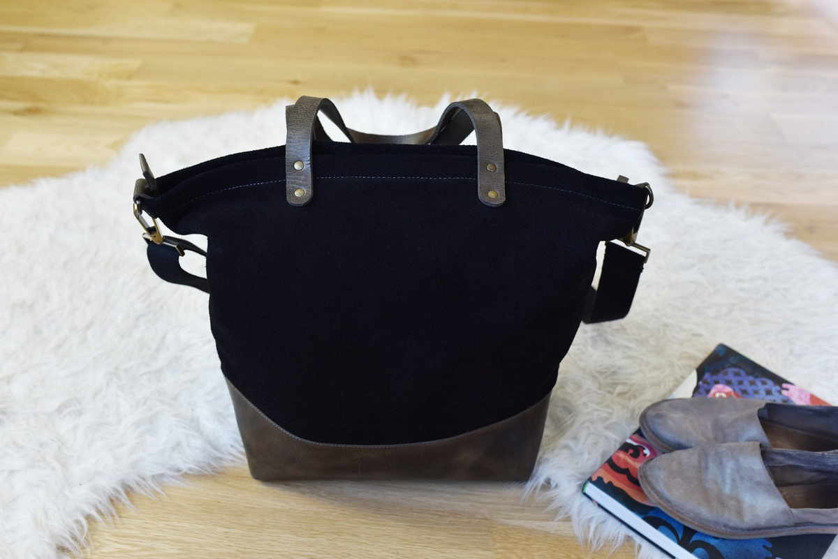 a black bag on a white fur rug