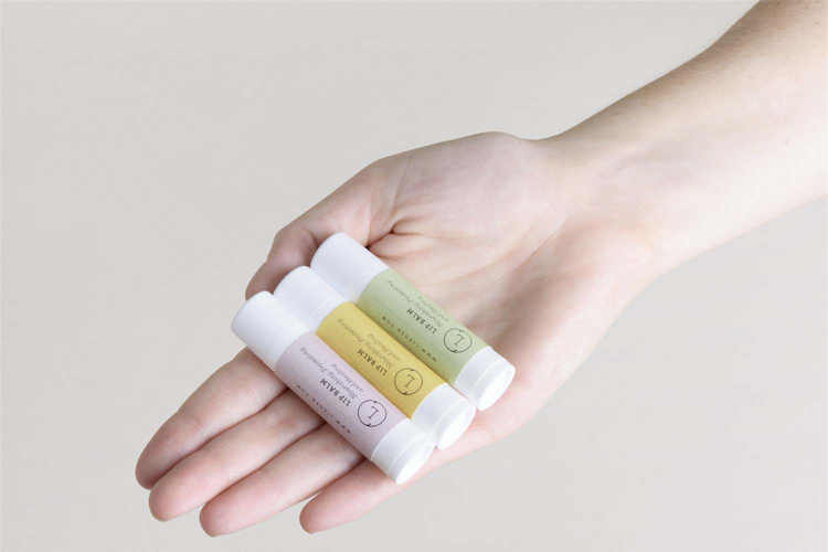 a hand holding small bottles of cream